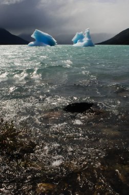 Two icebergs floating on the sea clipart