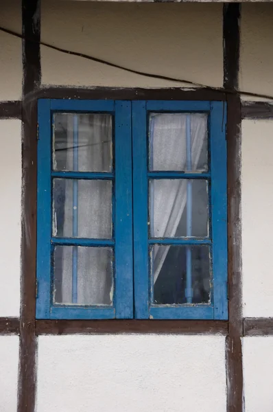 stock image Blue latticed window with curtain and brown framework