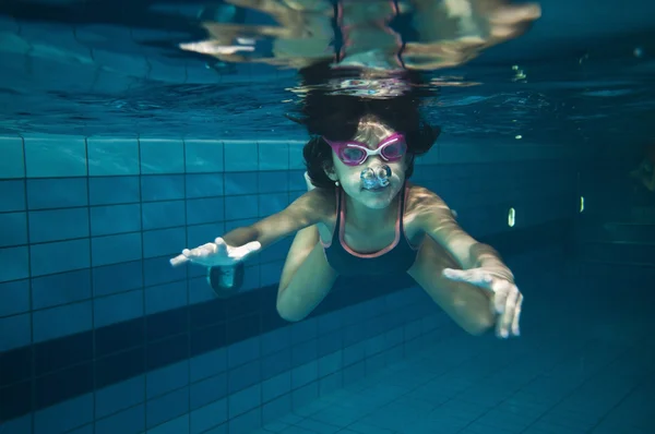 Menina feliz nadando debaixo d 'água na piscina — Fotografia de Stock
