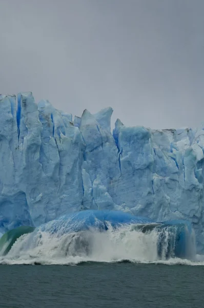 Blue iceberg falls out of massive glacier — Stock Photo, Image