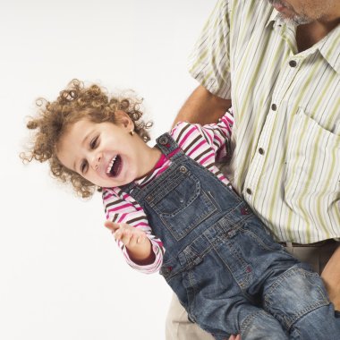 Father holding and playing with laughing toddler girl clipart