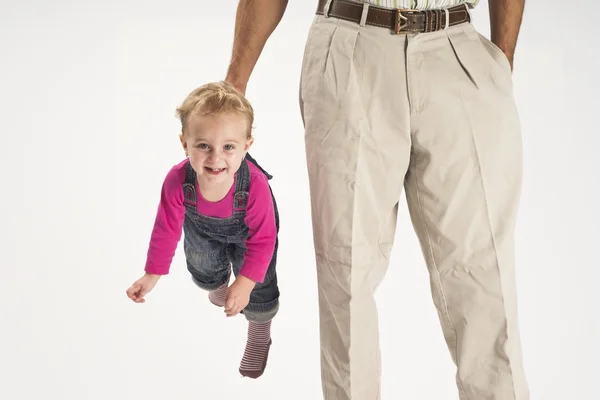 Father holding baby toddler suspended by suspenders — Stock Photo, Image