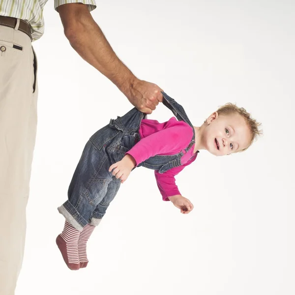 Ojciec trzymając malucha baby zawieszone przez szelki — Zdjęcie stockowe