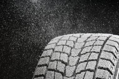 Studio close-up detail of winter tire tread full of snow clipart