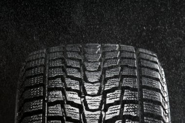 Studio close up of wet winter tire tread in the rain clipart