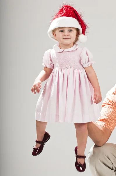 Söt baby barn santa hatt höll upp av far — Stockfoto