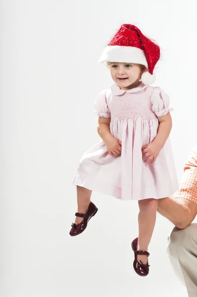 Cute baby toddler wearing santa's hat held up by father — Stock Photo, Image