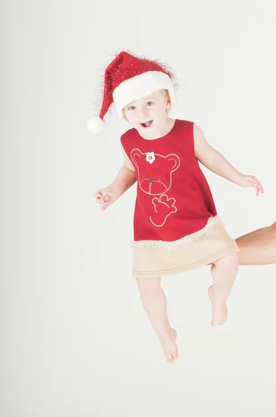 Cute baby toddler wearing santa's hat held up — Stock Photo, Image