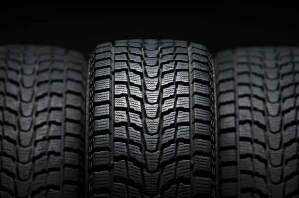 Três pneus pretos de inverno pisos — Fotografia de Stock