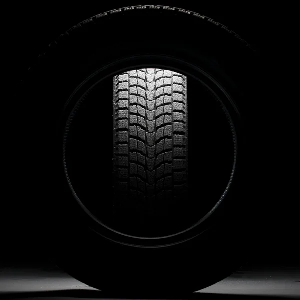 Preto nevado pneu de inverno visto através do buraco de outro pneu de inverno — Fotografia de Stock