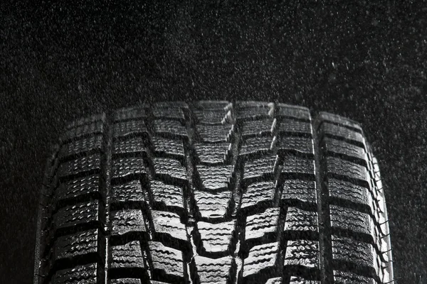 Estúdio perto de pneu de inverno molhado pisar na chuva — Fotografia de Stock