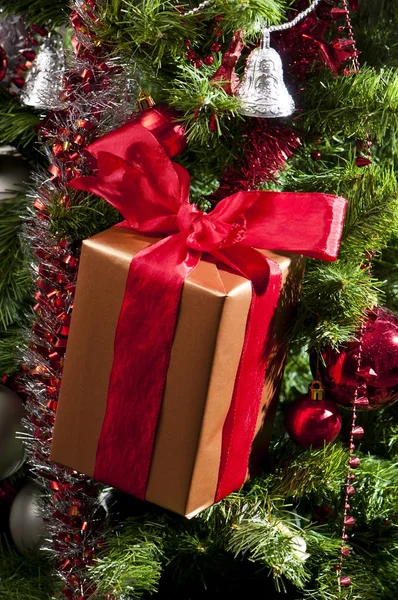 stock image Red ribboned gift on christmas tree