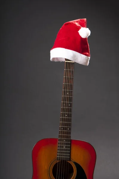 Classic accoustic guitar with santa claus' cap Royalty Free Stock Images