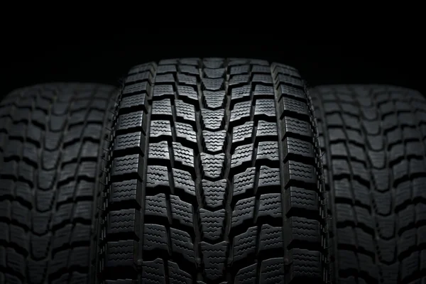 Three black winter tires in studio shot Stock Photo