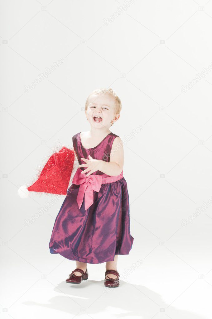 Happy dressed-up baby toddler girl with santas hat