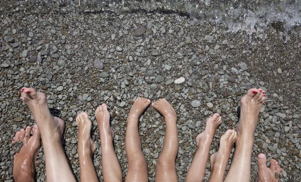 Los pies desnudos de una familia en la orilla del mar Fotos de stock libres de derechos
