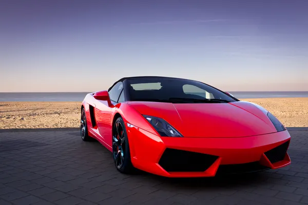 Червоний спортивний автомобіль на пляж заходу сонця — стокове фото