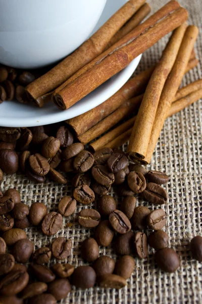 Coffee cup with beans and cinnamon sticks — Stock Photo, Image