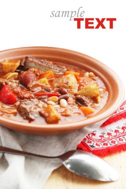 Hot soup with vegetables and meat clipart