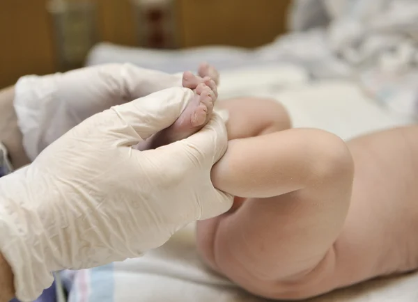 生まれたばかりの赤ちゃん - 筋肉の緊張と反射の検討 ストックフォト