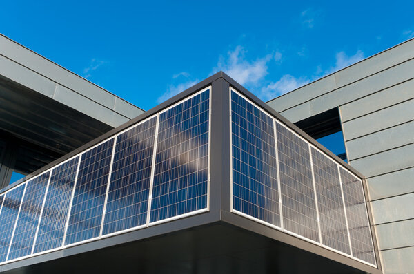 Entrance of a modern office building with solar panels for energy supply