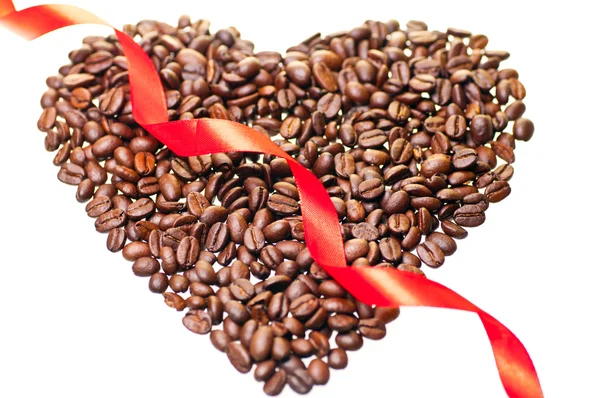 Grains de café en forme de coeur avec un ruban rouge à travers — Photo
