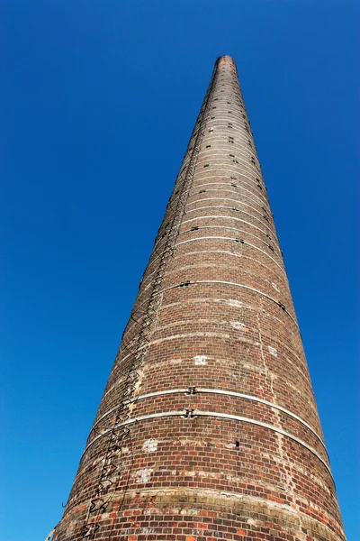stock image Industrial tall brick chimney against blue sky