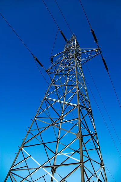 Alto pilone elettrico su cielo blu come sfondo — Foto Stock