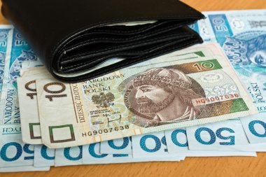 Polish money - zloty, banknotes and wallet on the table clipart