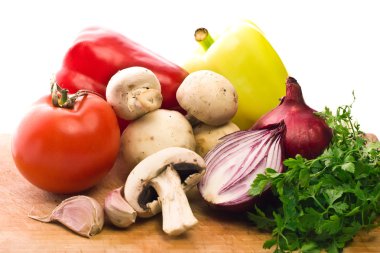 Vegetarian mix of mushrooms and fresh vegetables on wooden board