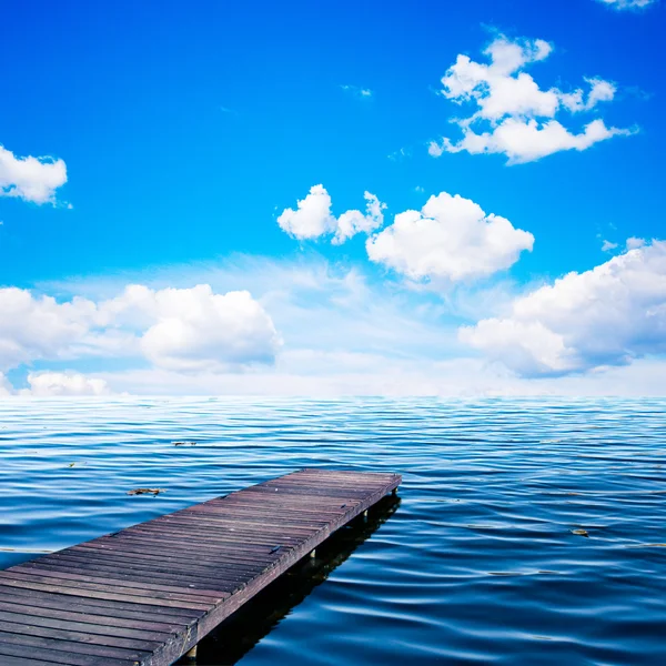 Деревянная банка, пирс на океане в летний вид на солнечный день, голубое небо и узор — стоковое фото