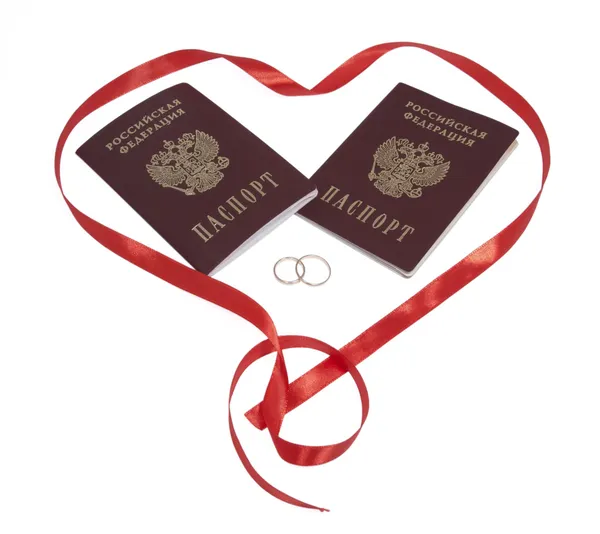 stock image Two passports, two golden rings in red heart, isolated.