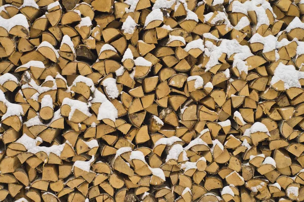 Pozadí. dřevníku suché palivového dřeva v zimě. — Stock fotografie