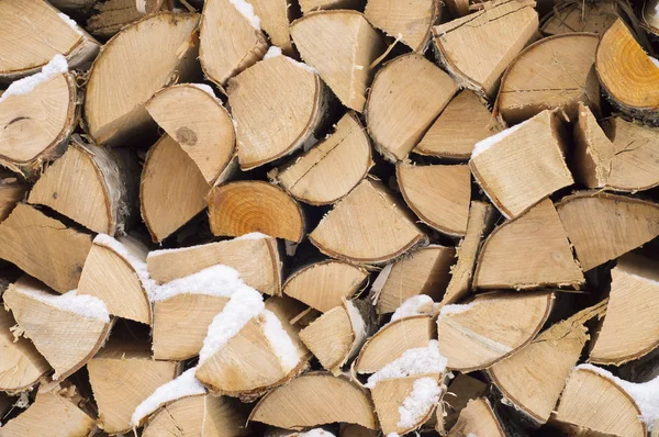 Achtergrond. een houtstapel van droge brandhout in de winter. — Stockfoto