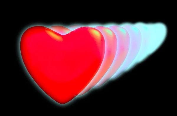 Eine Reihe abnehmender Herzen mit Neonlicht auf schwarzem Hintergrund — Stockfoto