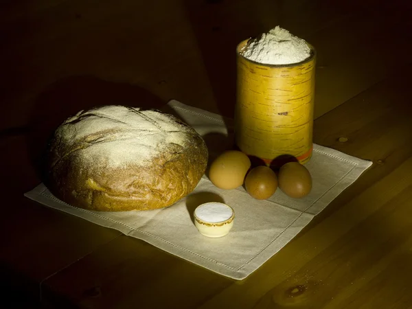 Pan de centeno, sal, harina en una caja y huevos en una servilleta de lino . — Foto de Stock
