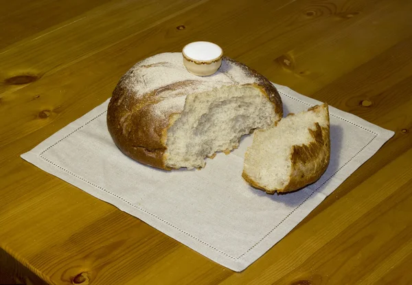 O pão com um saleiro em cima em um guardanapo de linho . — Fotografia de Stock