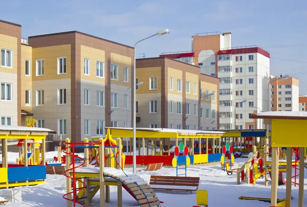 Новый детский сад с детской площадкой и новым многоэтажным зданием — стоковое фото