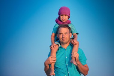 Little boy sitting on father's shoulders clipart