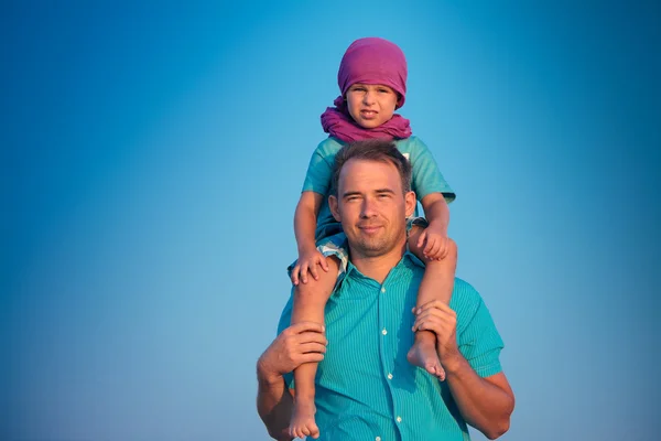 Küçük çocuk babasının omuzlarında oturan — Stok fotoğraf