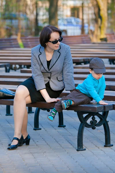 Mother and son sitting outdoors — Stock Photo, Image
