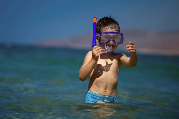 Un niño en un mar con una máscara de natación y snorkel —  Fotos de Stock
