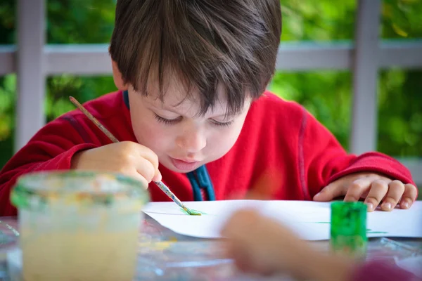 Три года, мальчик рисует кисточкой — стоковое фото