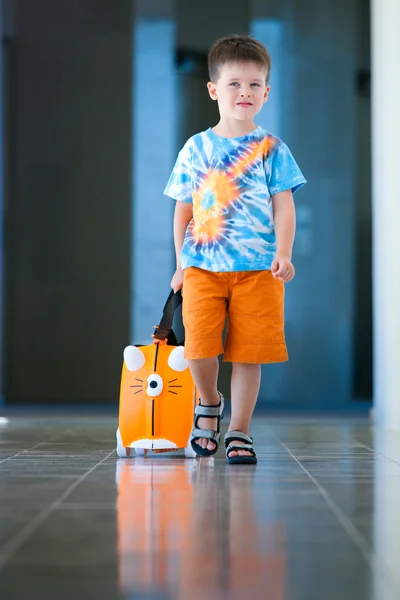 Мальчик с чемоданом в аэропорту — стоковое фото
