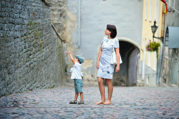 Mamma och hennes lilla son promenader i city — Stockfoto