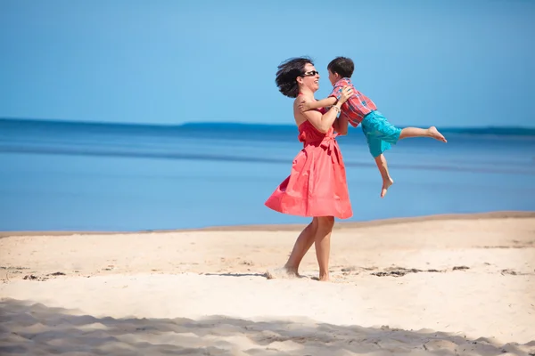 Mor og hennes lille sønn leker på stranda. – stockfoto