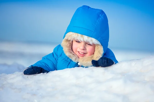 Портрет маленького мальчика, играющего в снегу — стоковое фото