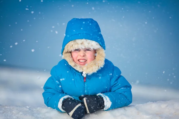 Портрет маленького мальчика, играющего в снегу — стоковое фото