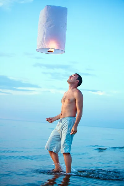 A young man with a fire lantern — Stock Photo, Image