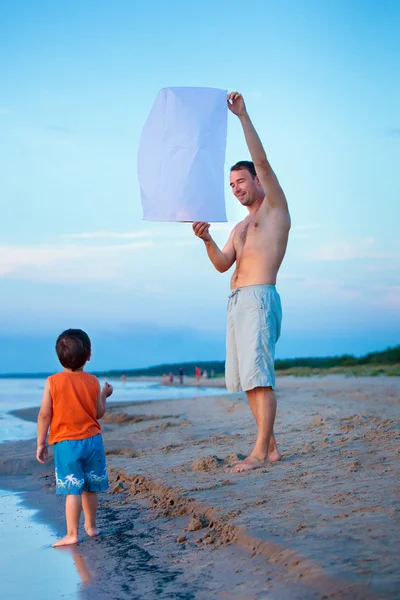 Gelukkig vader en zoon vliegen brand lantaarn samen — Stockfoto